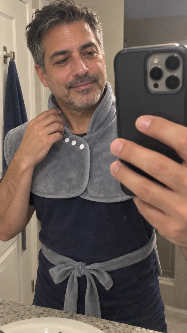 A man taking a bathroom mirror selfie while adjusting the Warmith collar.