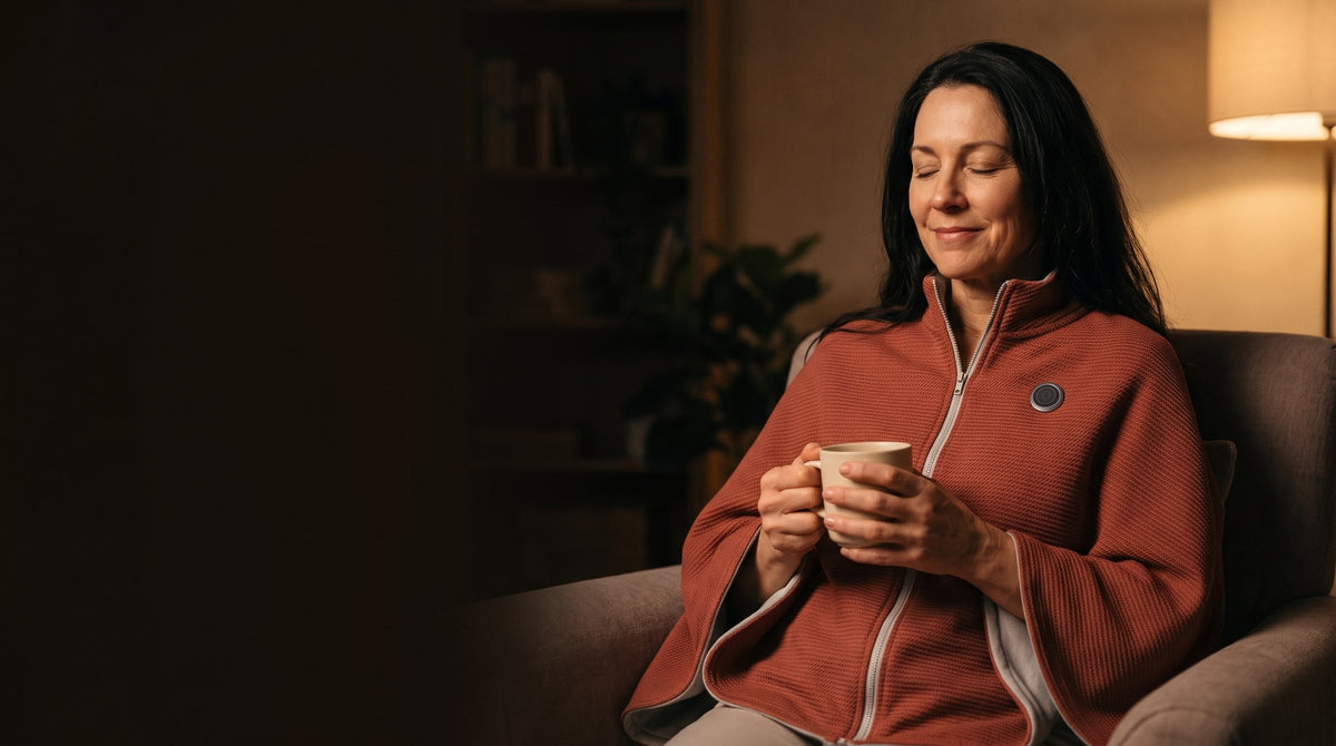 Woman in the brick red wrap relaxing in a reading chair by lamplight