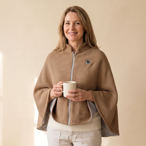Woman wearing the brown Warmith heated shawl wrap zipped, holding a mug [Brown]