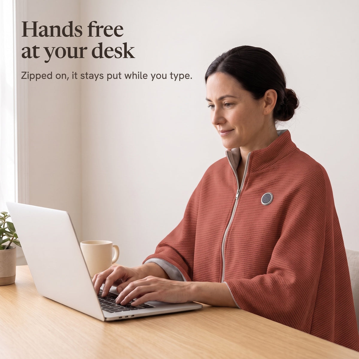 Woman typing at a desk in the brick red wrap, hands free