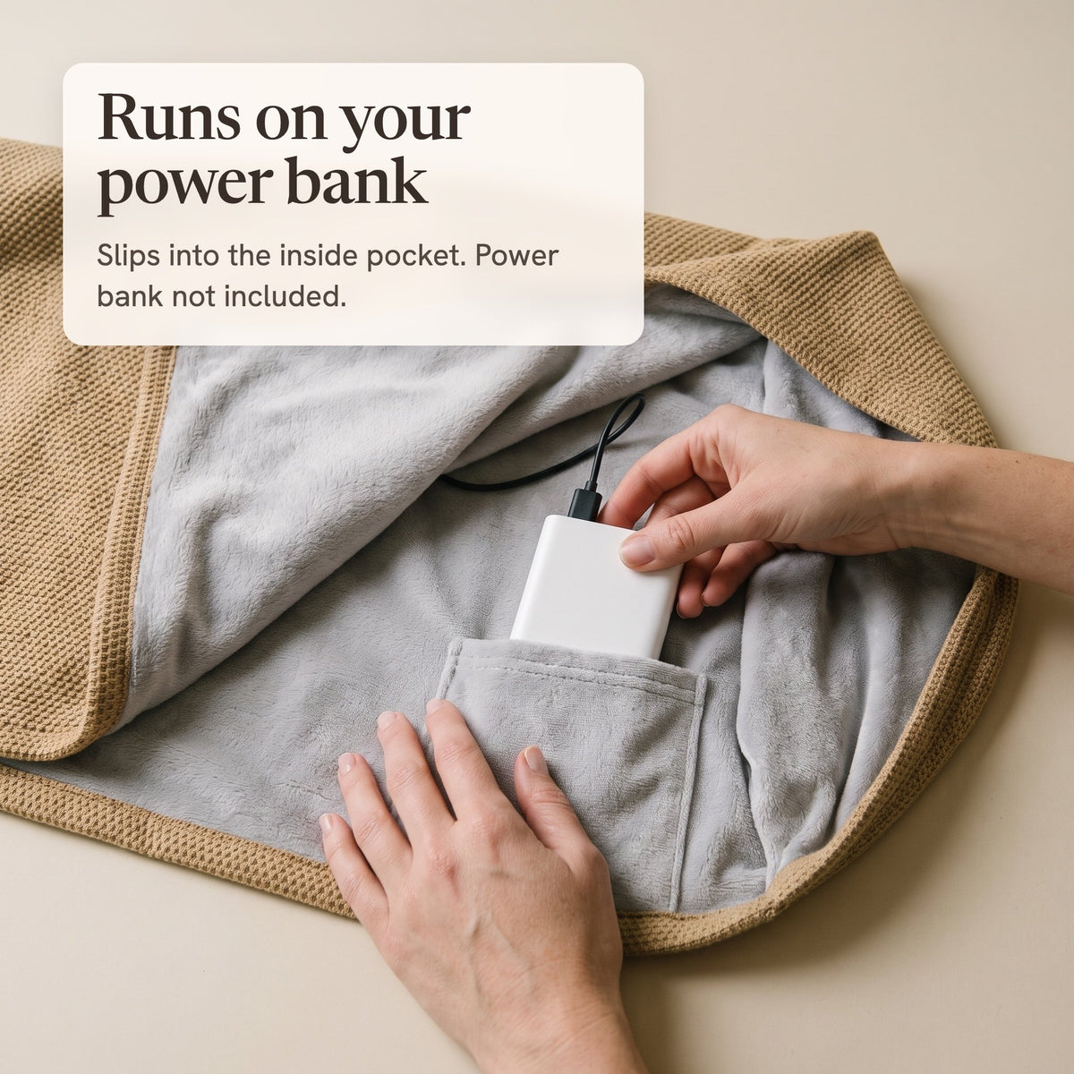 Hands sliding a white power bank into the inside pocket of the camel wrap