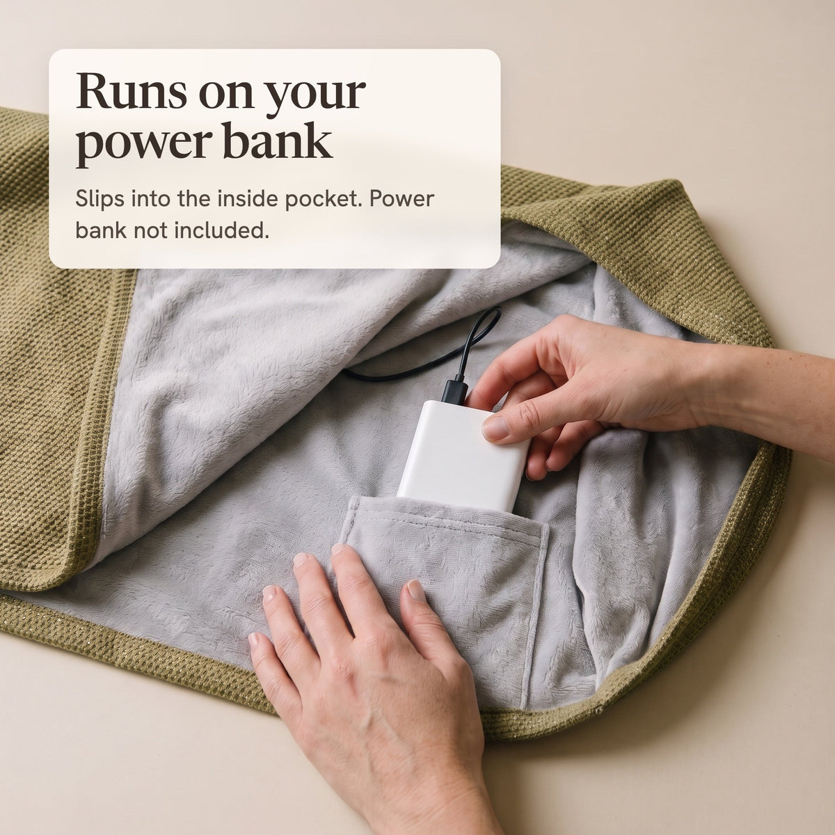 Hands sliding a white power bank into the inside pocket of the olive wrap