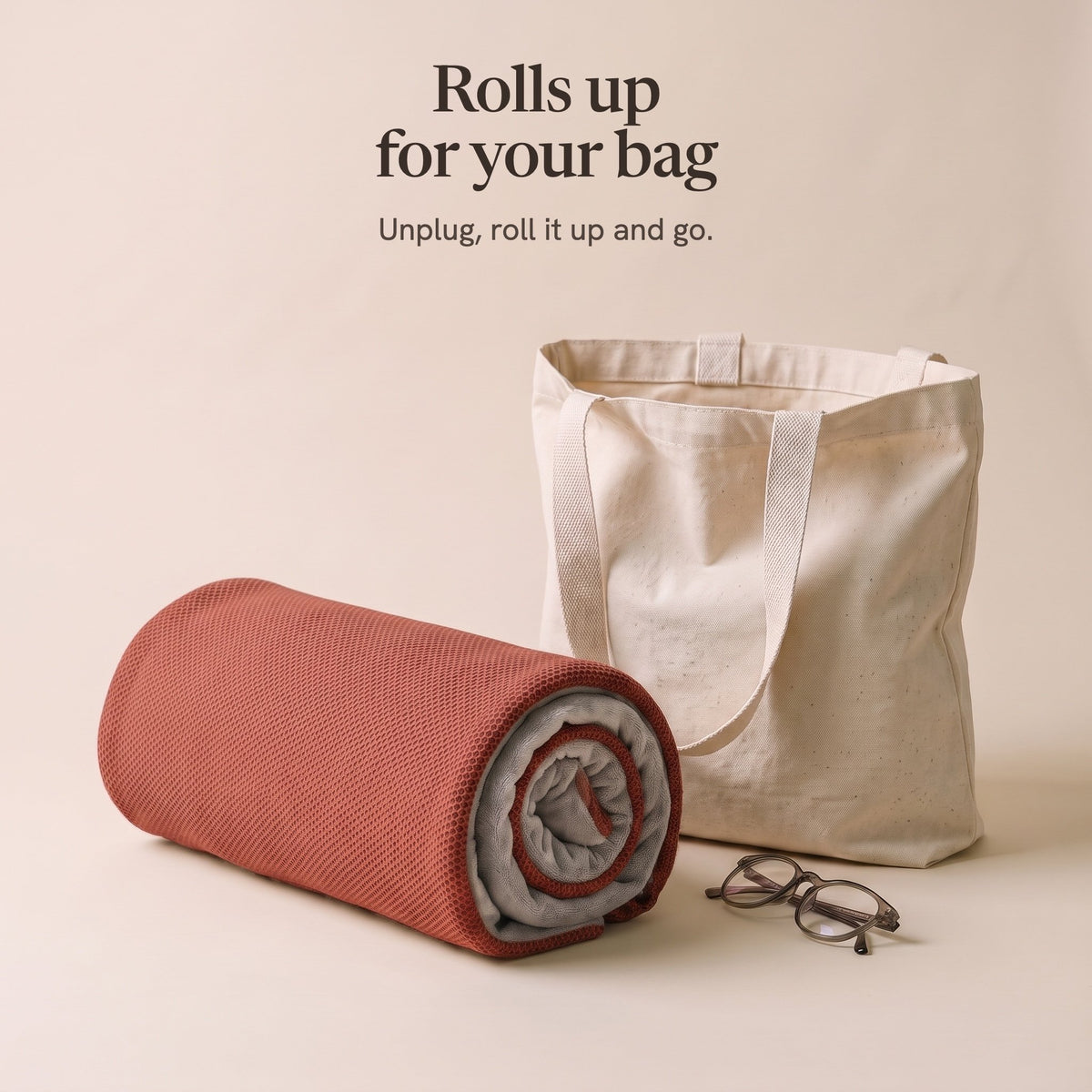 The brick red wrap rolled up beside a canvas tote