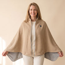 Woman holding the open camel wrap out at her sides to show its width