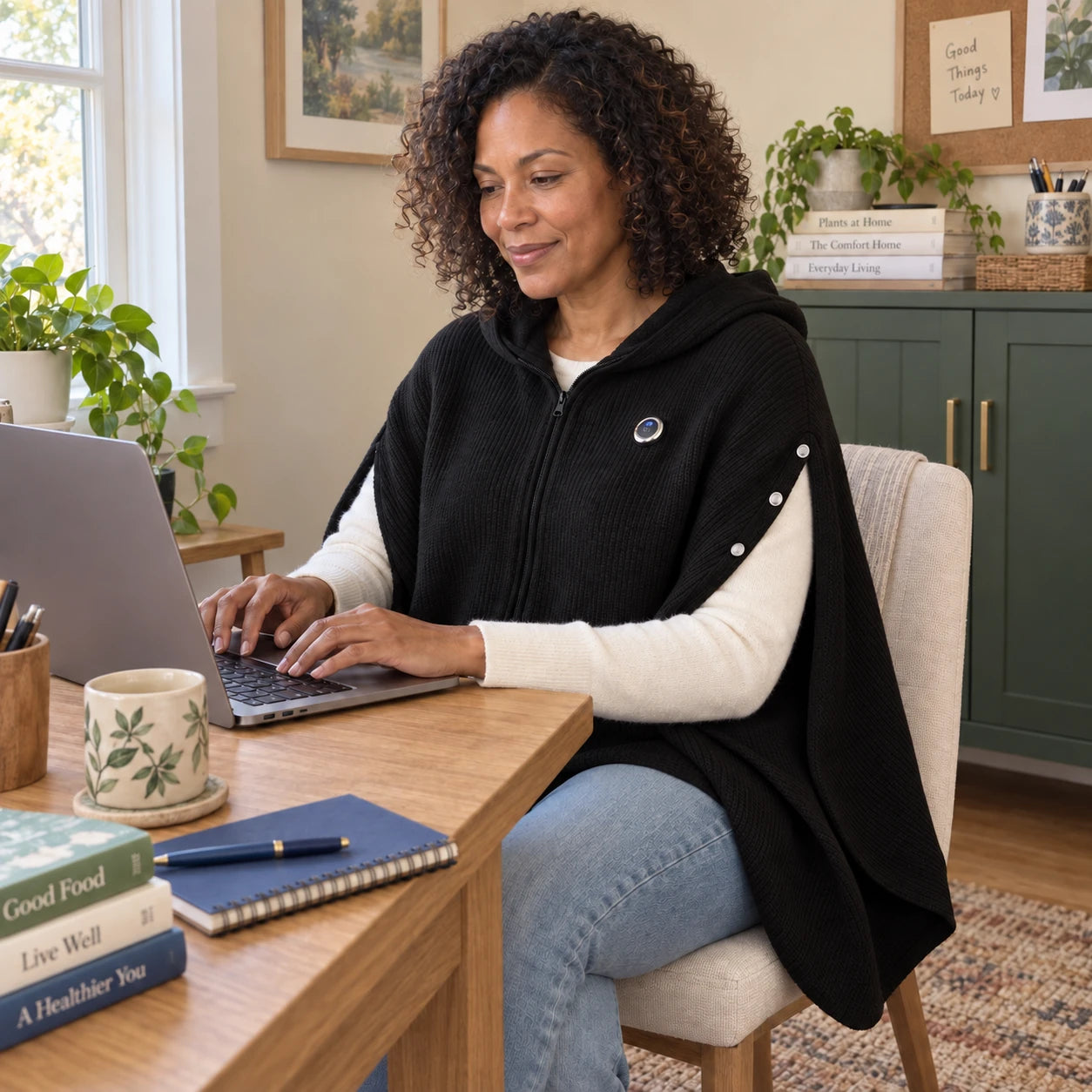 Woman using a laptop with both arms free through the poncho’s side openings.